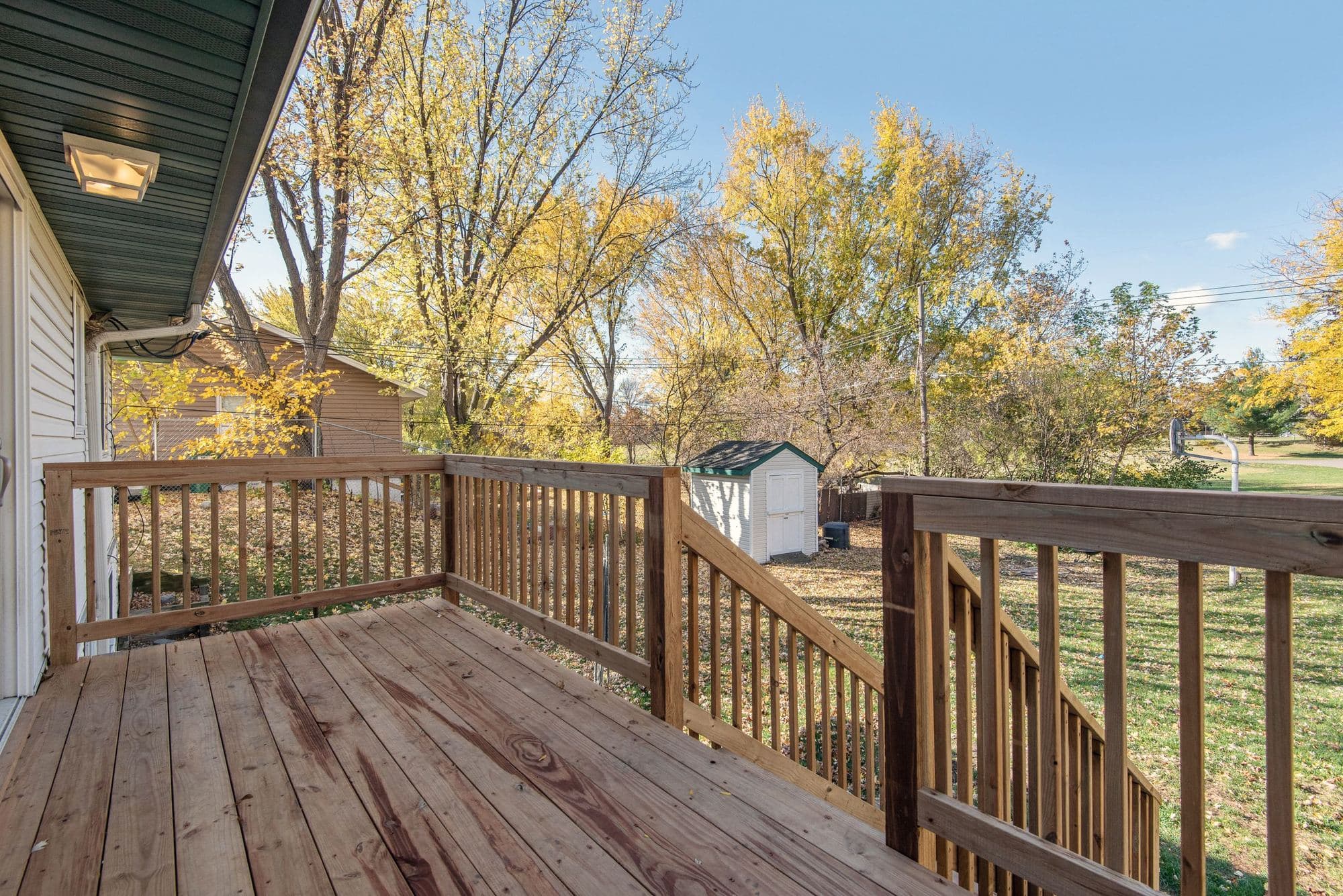 Finished wood deck with matching wood railings in a residential backyard