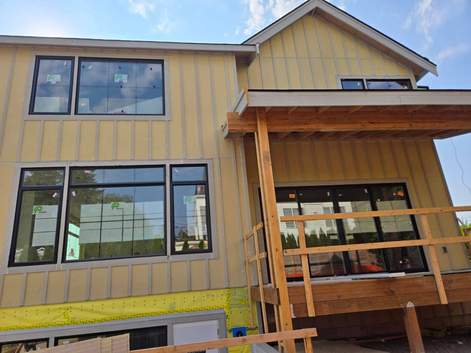 Board-and-batten siding with black windows and deck