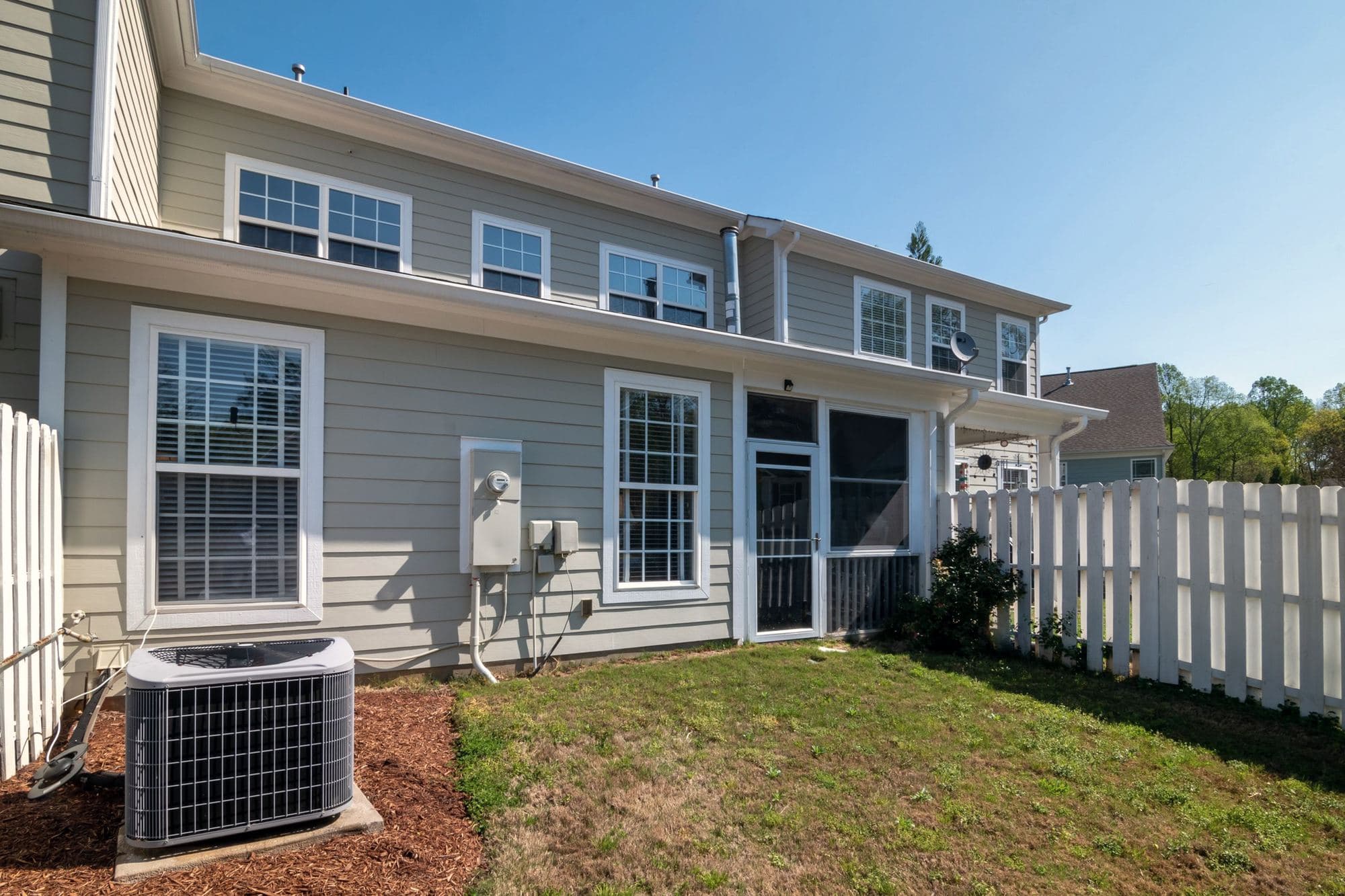 White double-hung windows on the side of a gray lap-sided two-story home